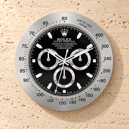 Daytona Wanduhr – Silber & Schwarz (Modell 001) – Vorderansicht an einer hellen Steinwand