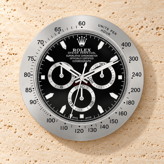 Daytona Wanduhr – Silber & Schwarz (Modell 001) – Vorderansicht an einer hellen Steinwand