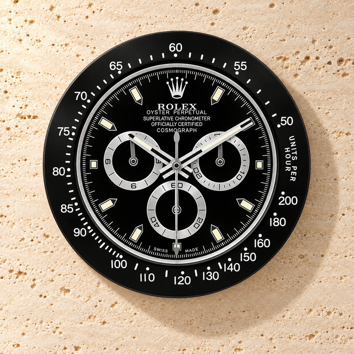 Daytona Wanduhr – Schwarz (Modell 009) – Vorderansicht an einer hellen Steinwand