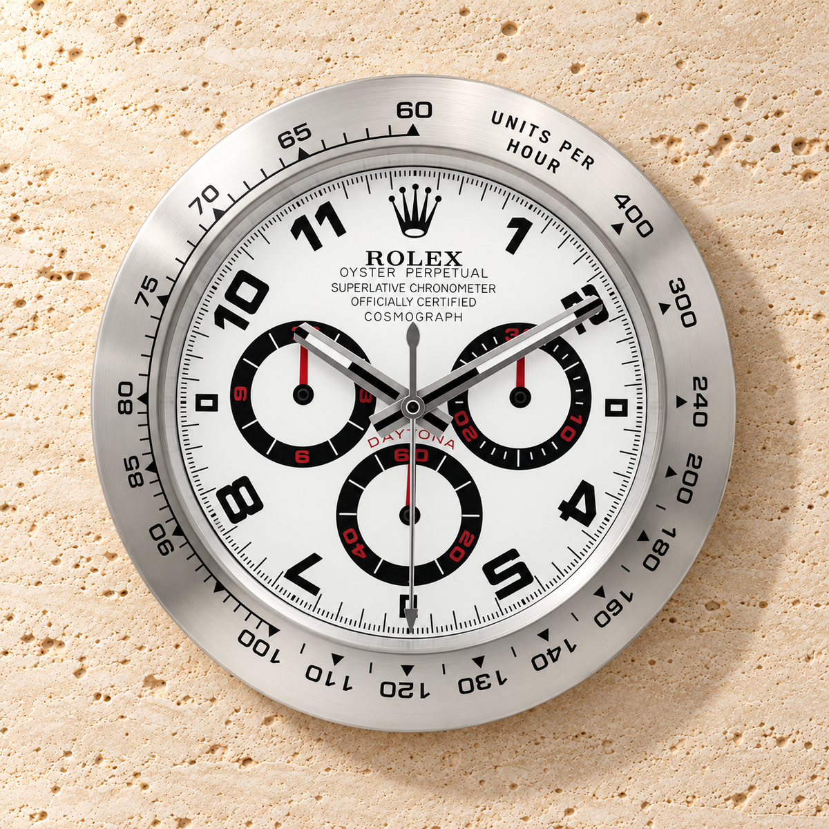 Daytona Wanduhr – Silber & Weiß mit arabischen Ziffern – Vorderansicht an einer hellen Steinwand
