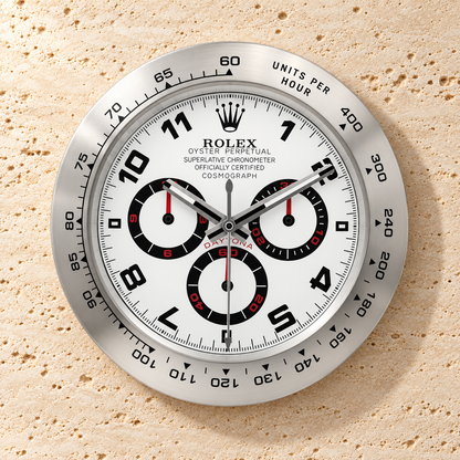 Daytona Wanduhr – Silber & Weiß mit arabischen Ziffern – Vorderansicht an einer hellen Steinwand