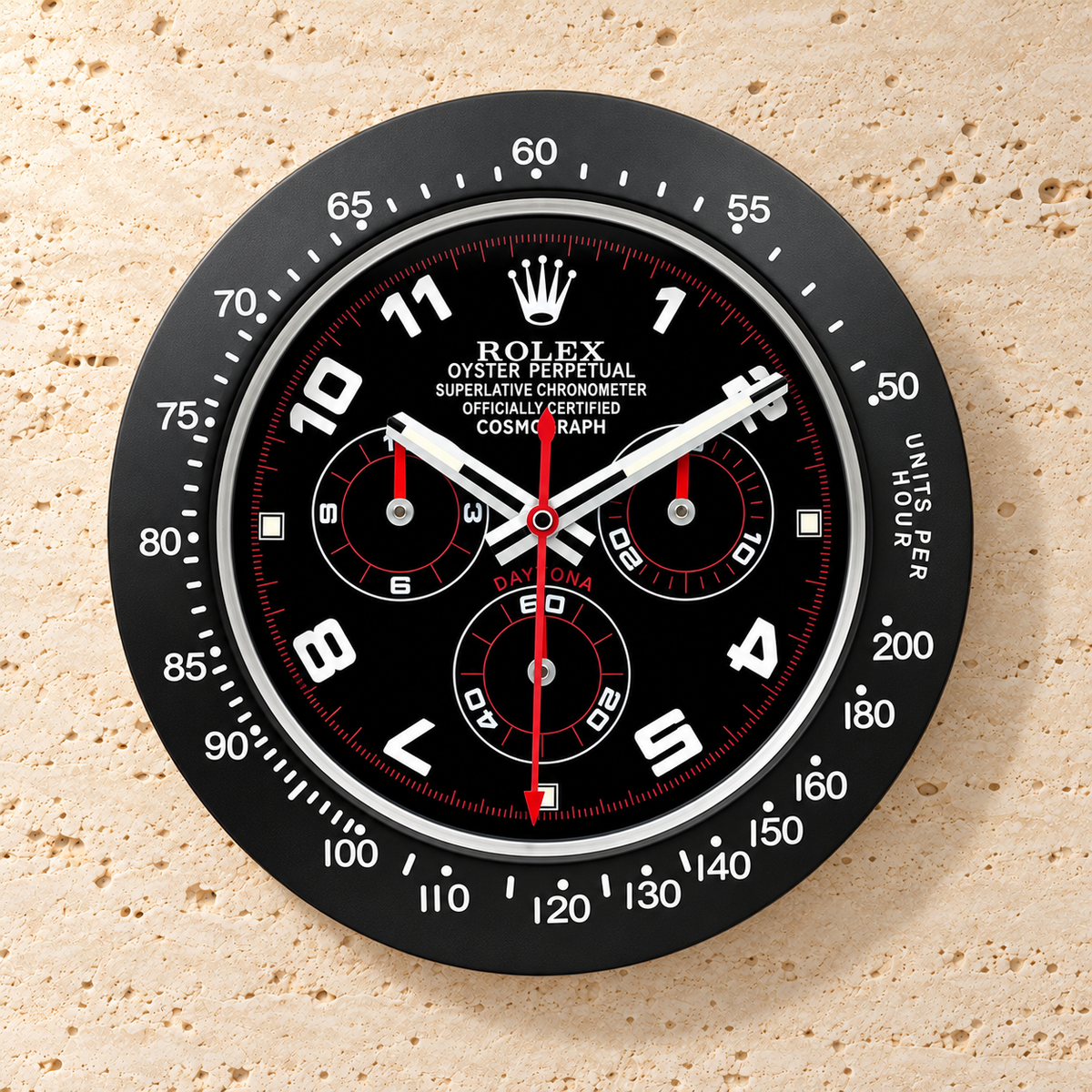 Daytona Wanduhr – Schwarz (Modell 014) – Vorderansicht an einer hellen Steinwand