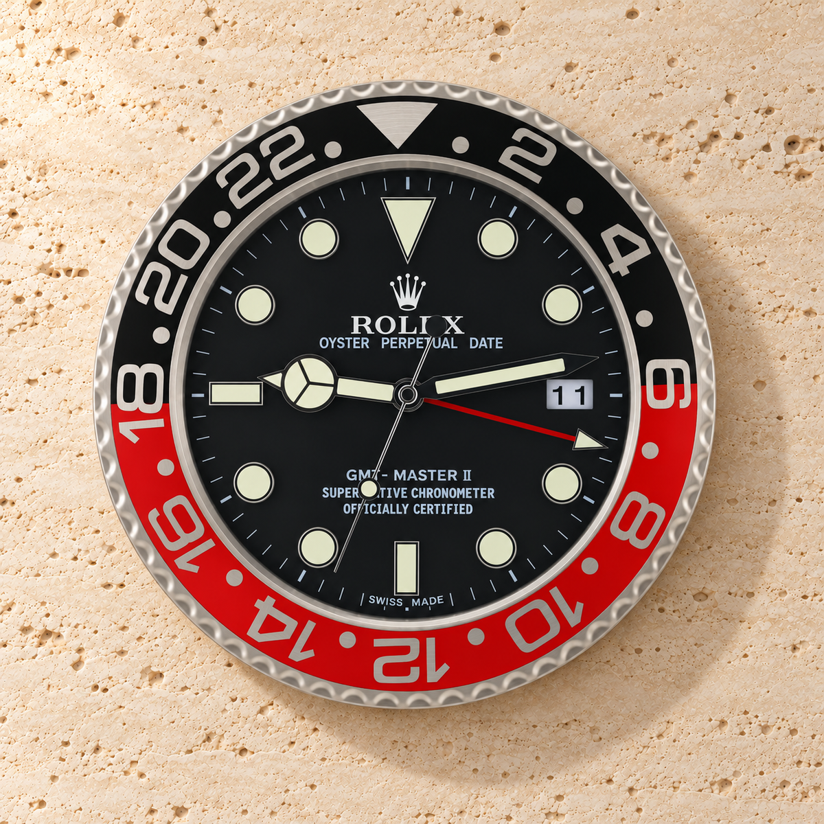 GMT-Master Wanduhr – Schwarz & Rot – Vorderansicht an einer hellen Steinwand