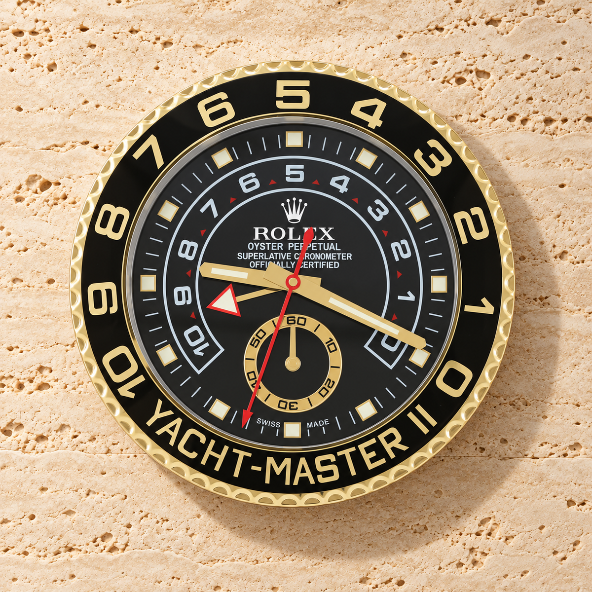 Yacht-Master II Wanduhr – Gold & Schwarz an einer hellen Travertinwand