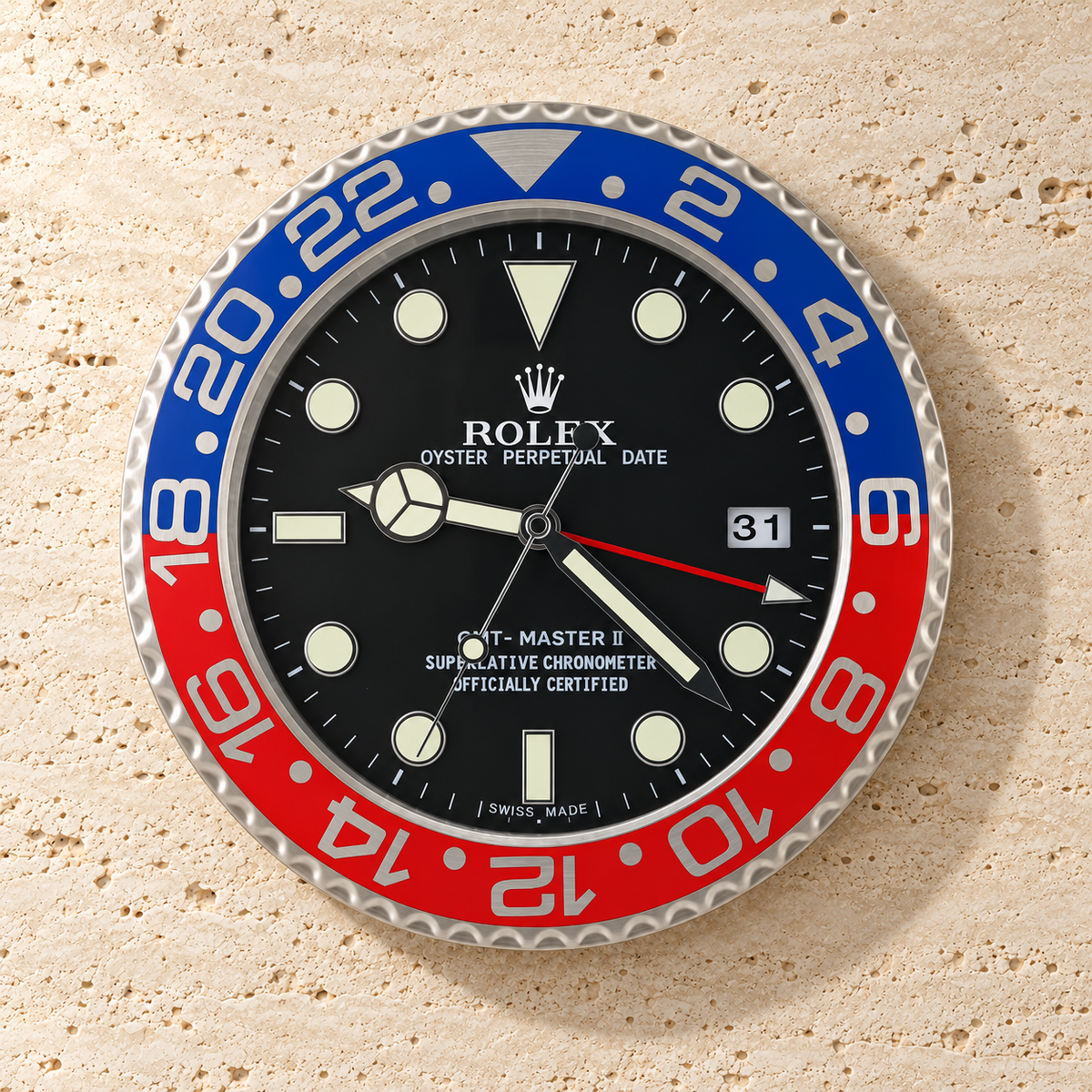 GMT-Master Wanduhr in Rot und Blau mit schwarzem Zifferblatt an einer hellen Steinwand