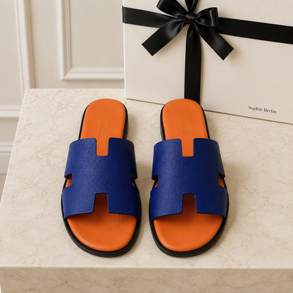 Izmir Herrenpantolette in Blau und Orange – liegendes Paar auf Travertin