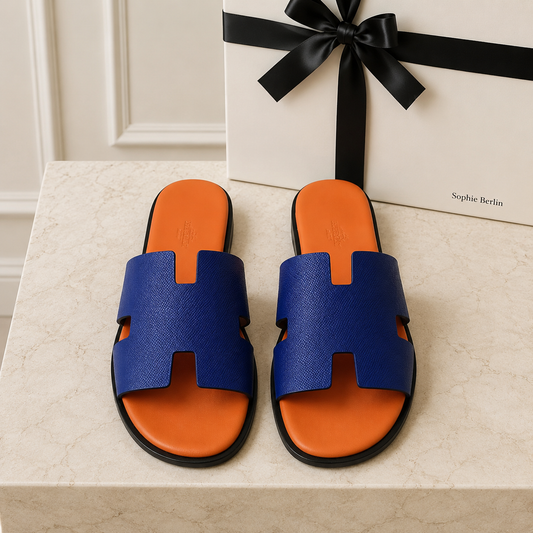 Izmir Herrenpantolette in Blau und Orange – liegendes Paar auf Travertin